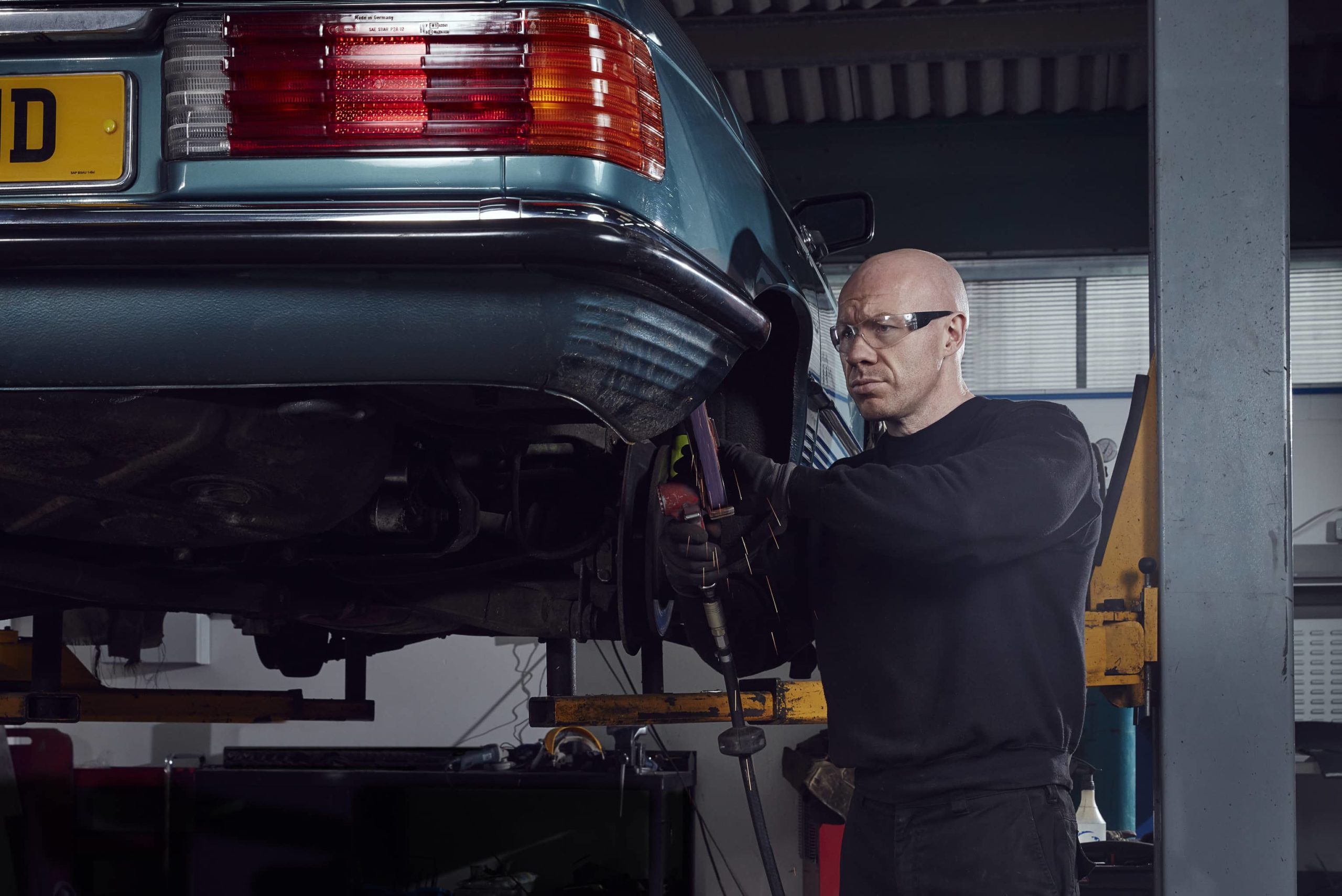 SLSHOP technician inspecting and welding a classic Mercedes