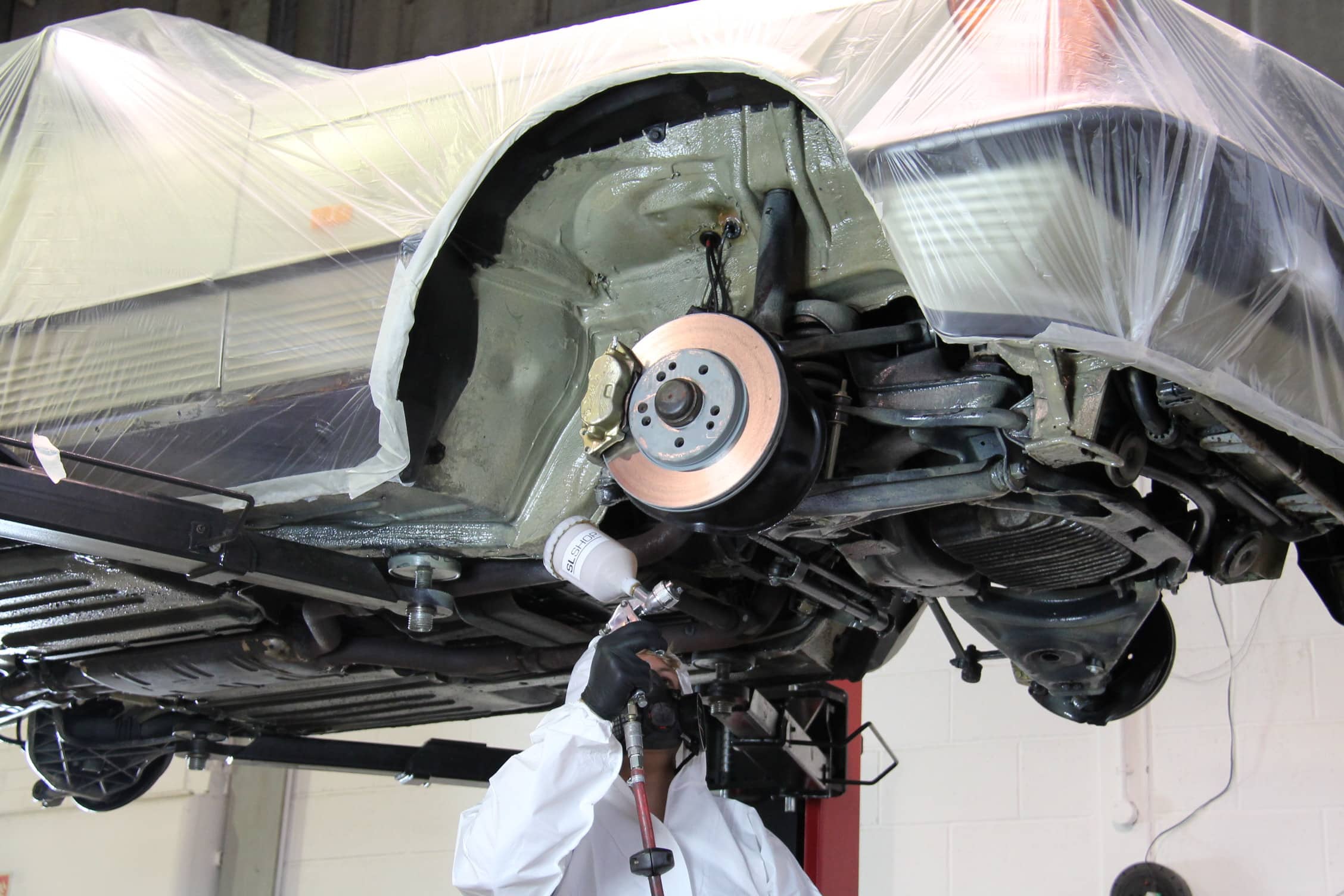 Man viewing undercarriage during R107 bulkhead repair 