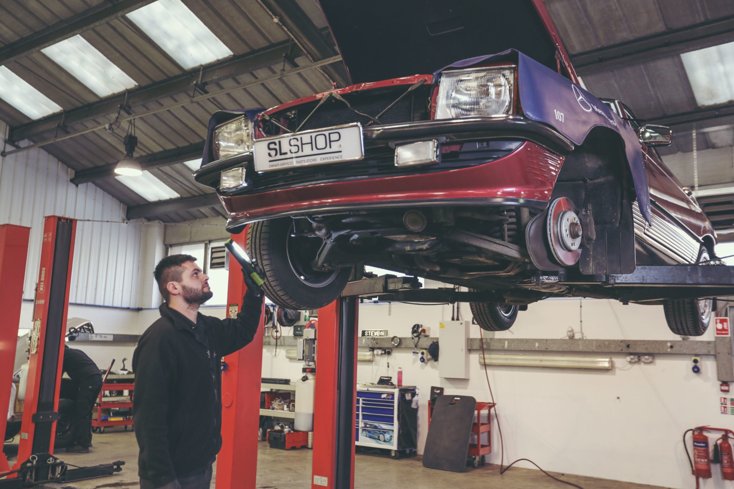 Mechanic investigating a classic Mercedes.