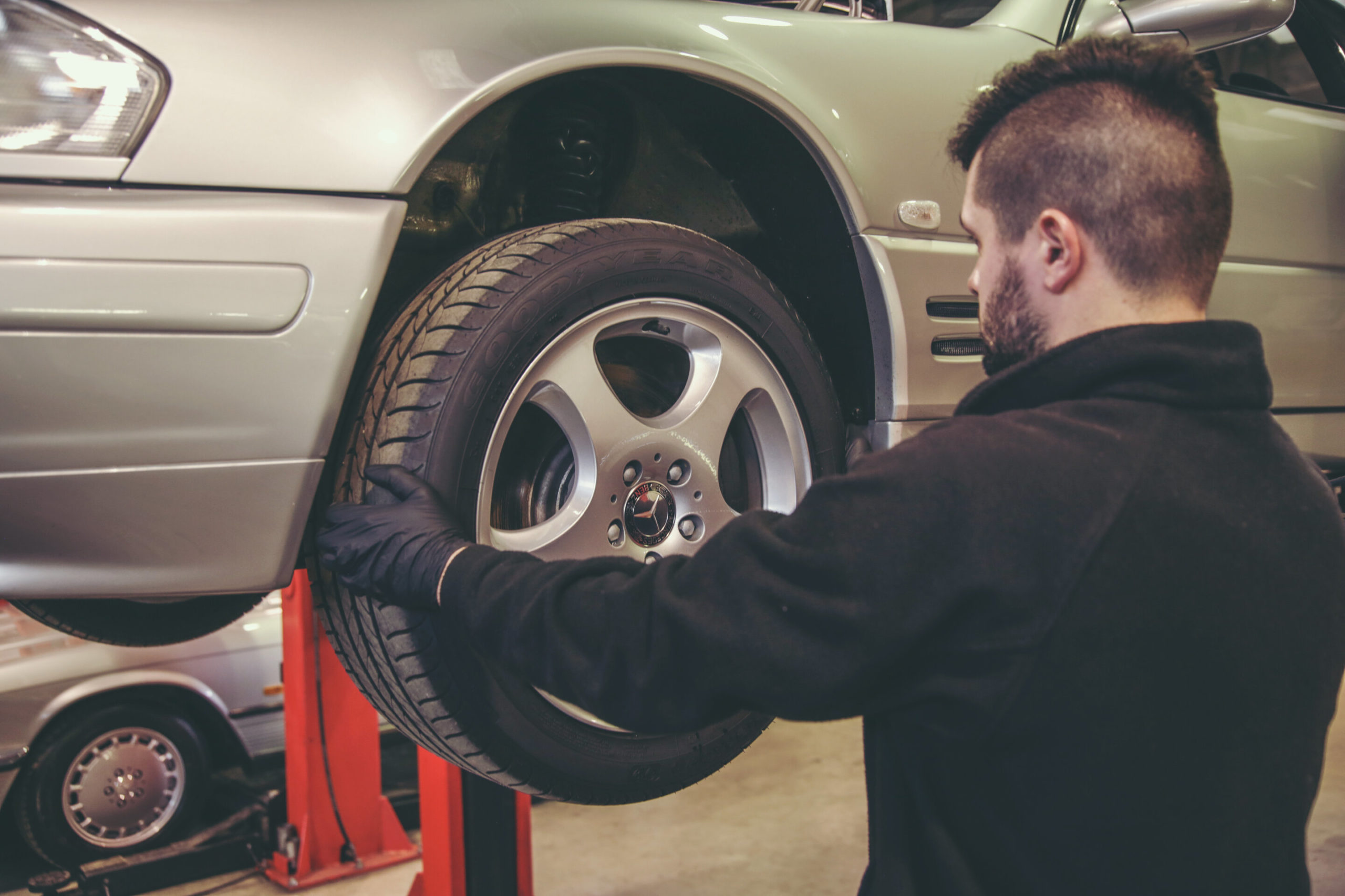 Mechanic removing wheel from R129 SL.