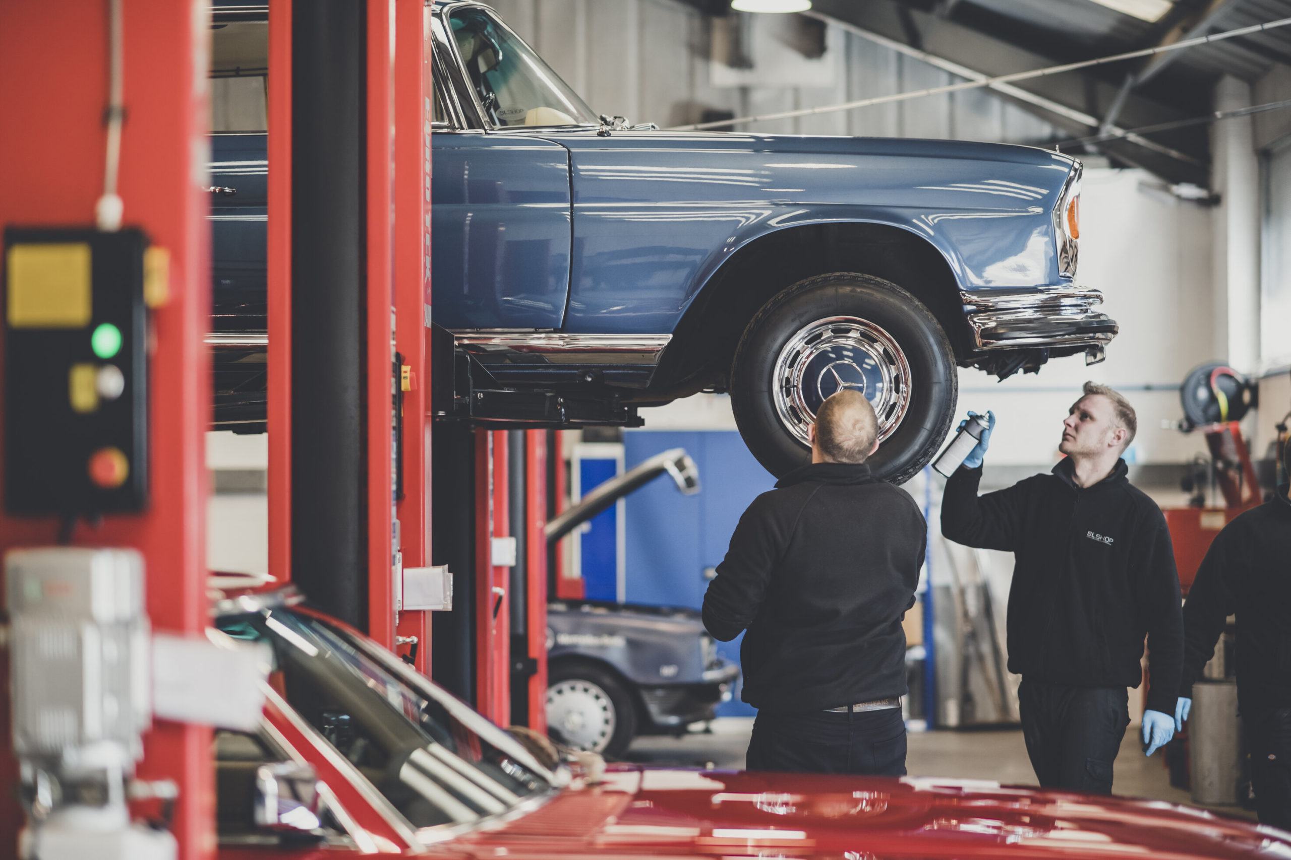 Mechanic removing engine cover on a R129 SL.